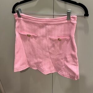 Pink mini skirt with gold button and pocket detail